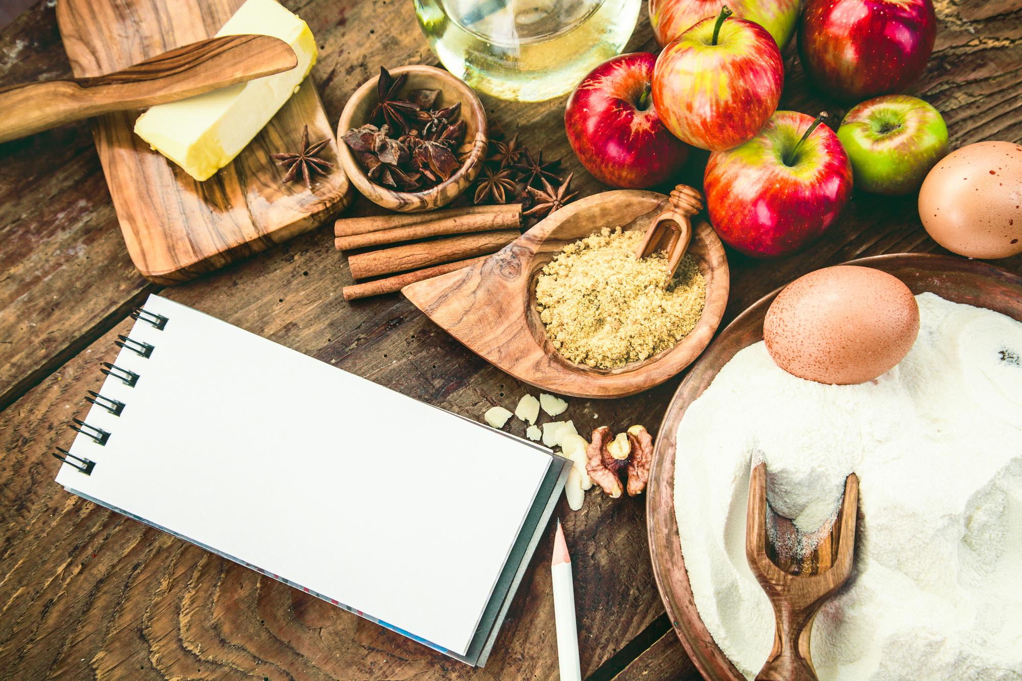 Tavolo con ingredienti locali e manoscritti di ricette